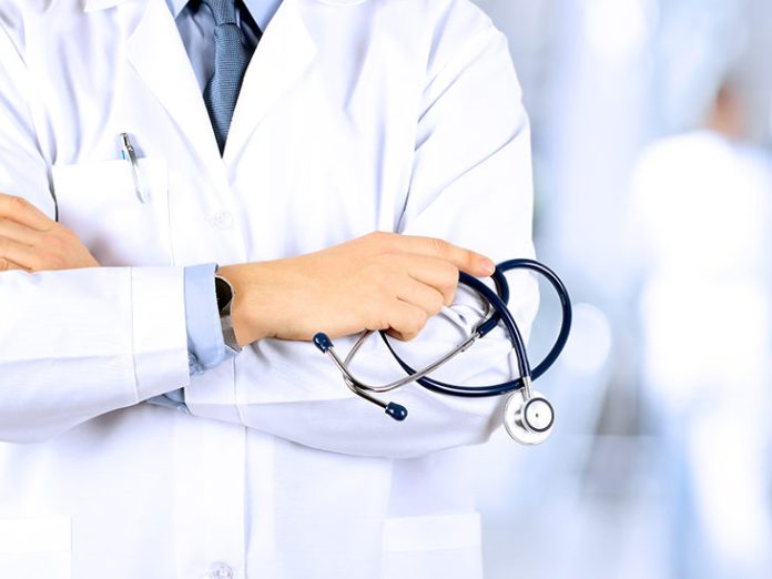 Portrait an unknown male doctor holding a stethoscope behind